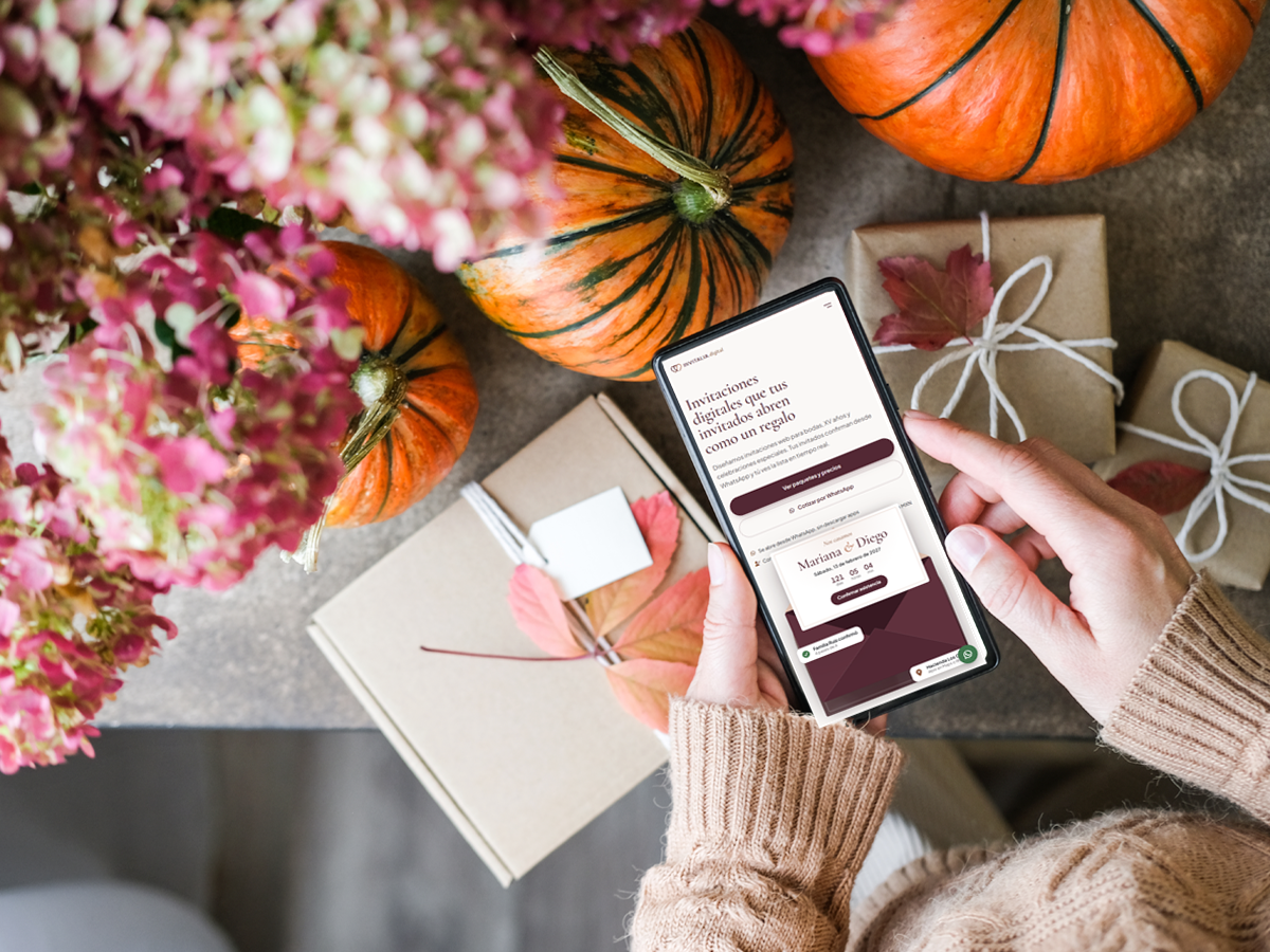 Celular mostrando una invitación web de boda sobre una mesa decorada