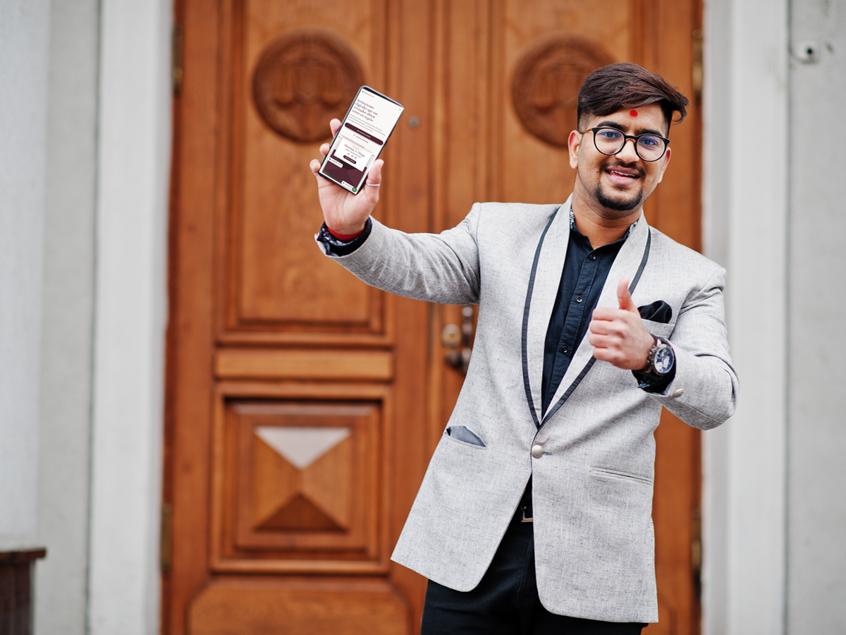 Invitado mostrando su pase digital en el celular a la entrada de un salón